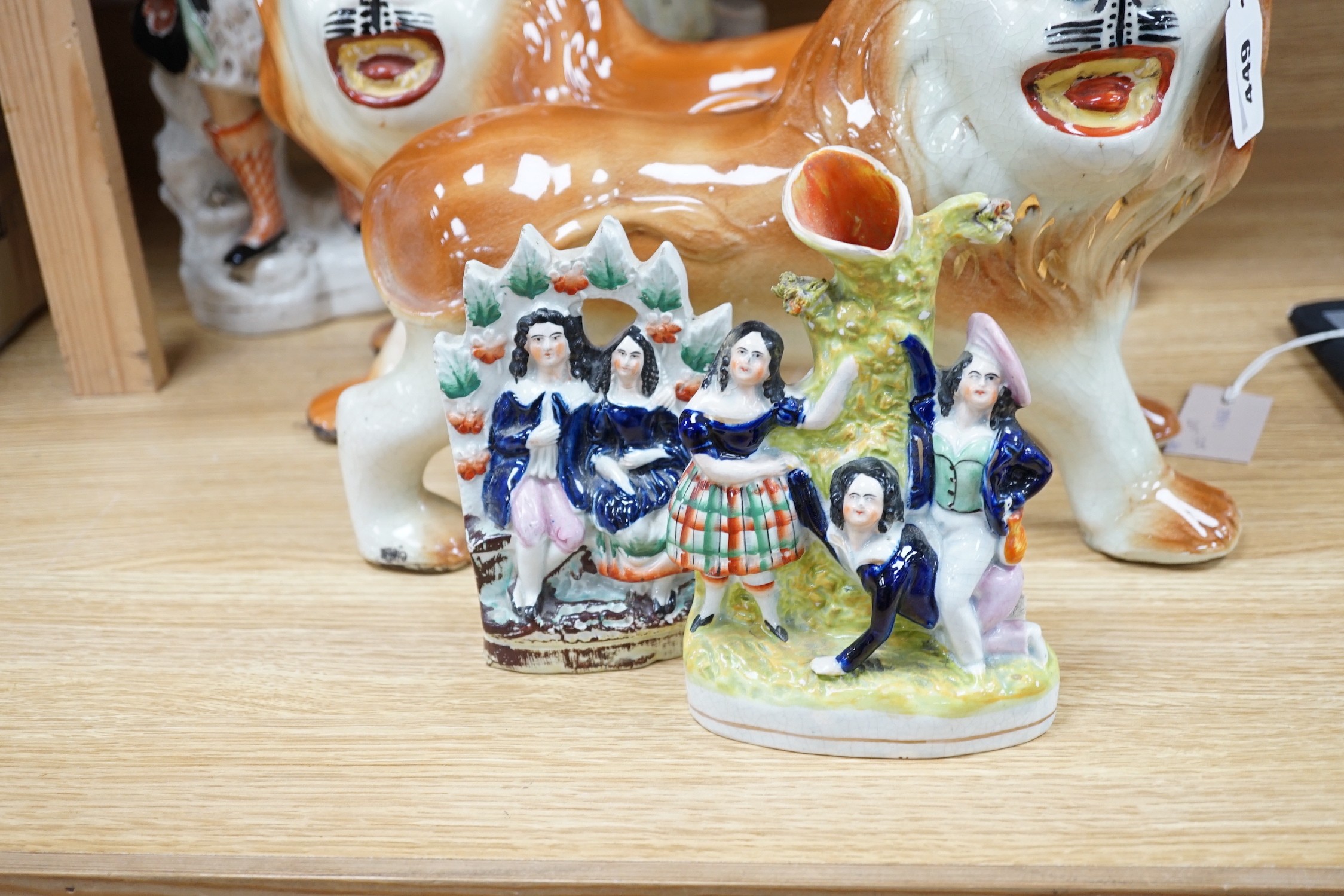 A group of 19th century Staffordshire flat backs and a pair of late Staffordshire pottery lions, 40cms wide